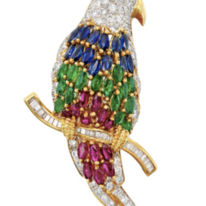 Parrot brooch with diamonds, emeralds, sapphires and baguette diamonds perching on twig